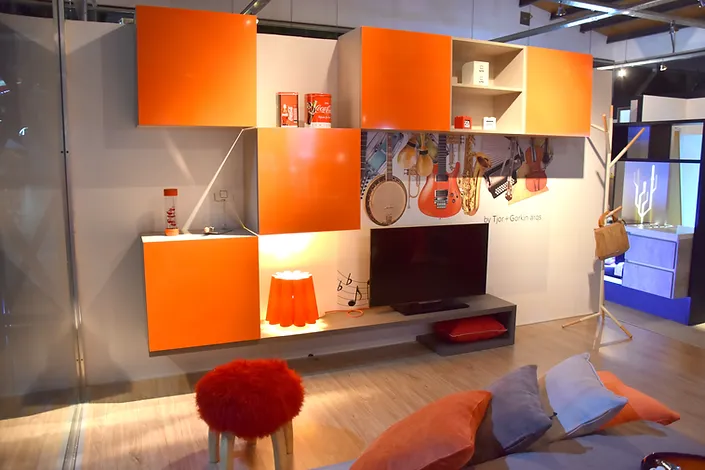 Complemento luminoso de color naranja para el televisor, con una ilustracion de guitarra de fondo